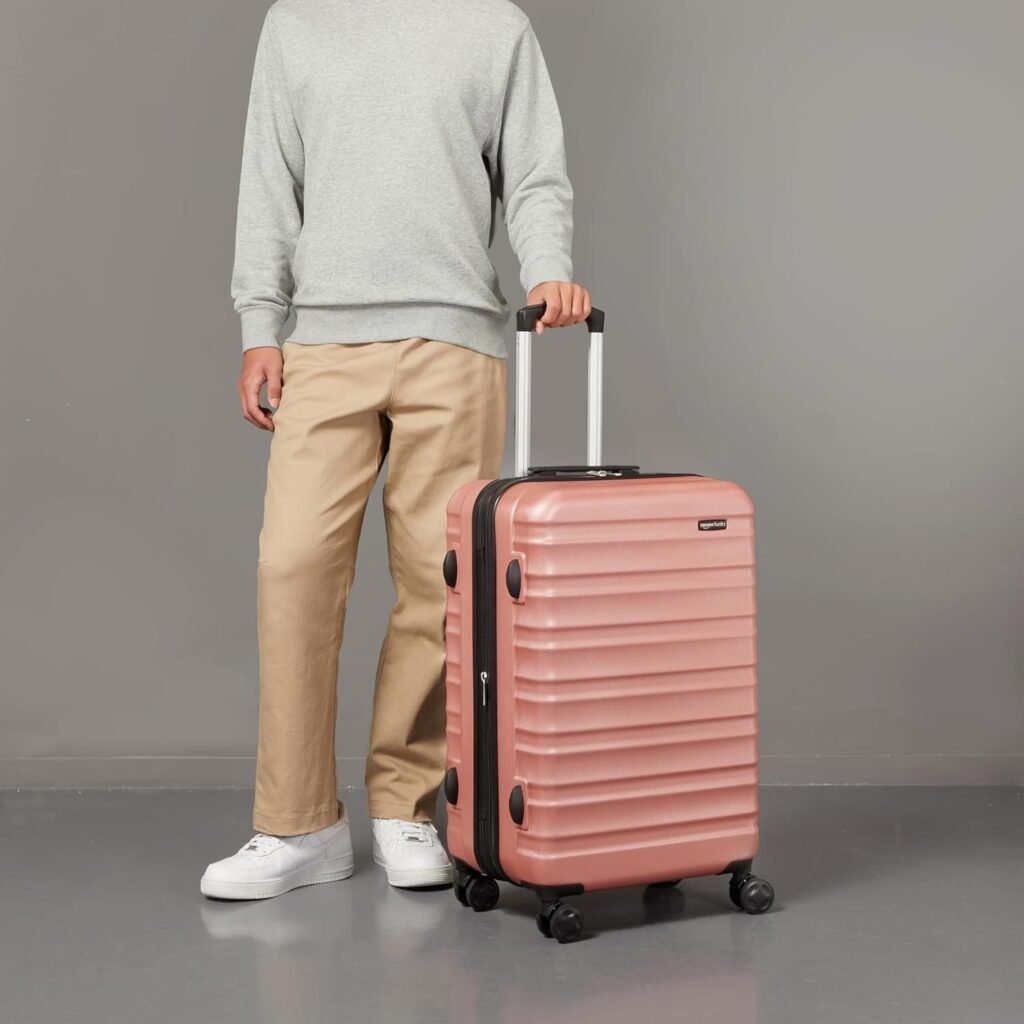 Avis Valise Amazon Basics un homme et sa valise rose pose
